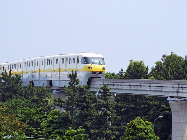 A yellow and white train on the Disney Resort Monorail in Japan