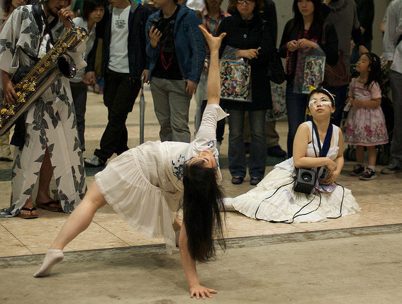Women dance while a man dressed in a yukata plays the saxophone at Design Festa in Tokyo Big Sight