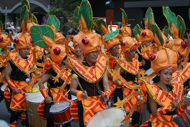 A group of samba drummers wearing orange costumes